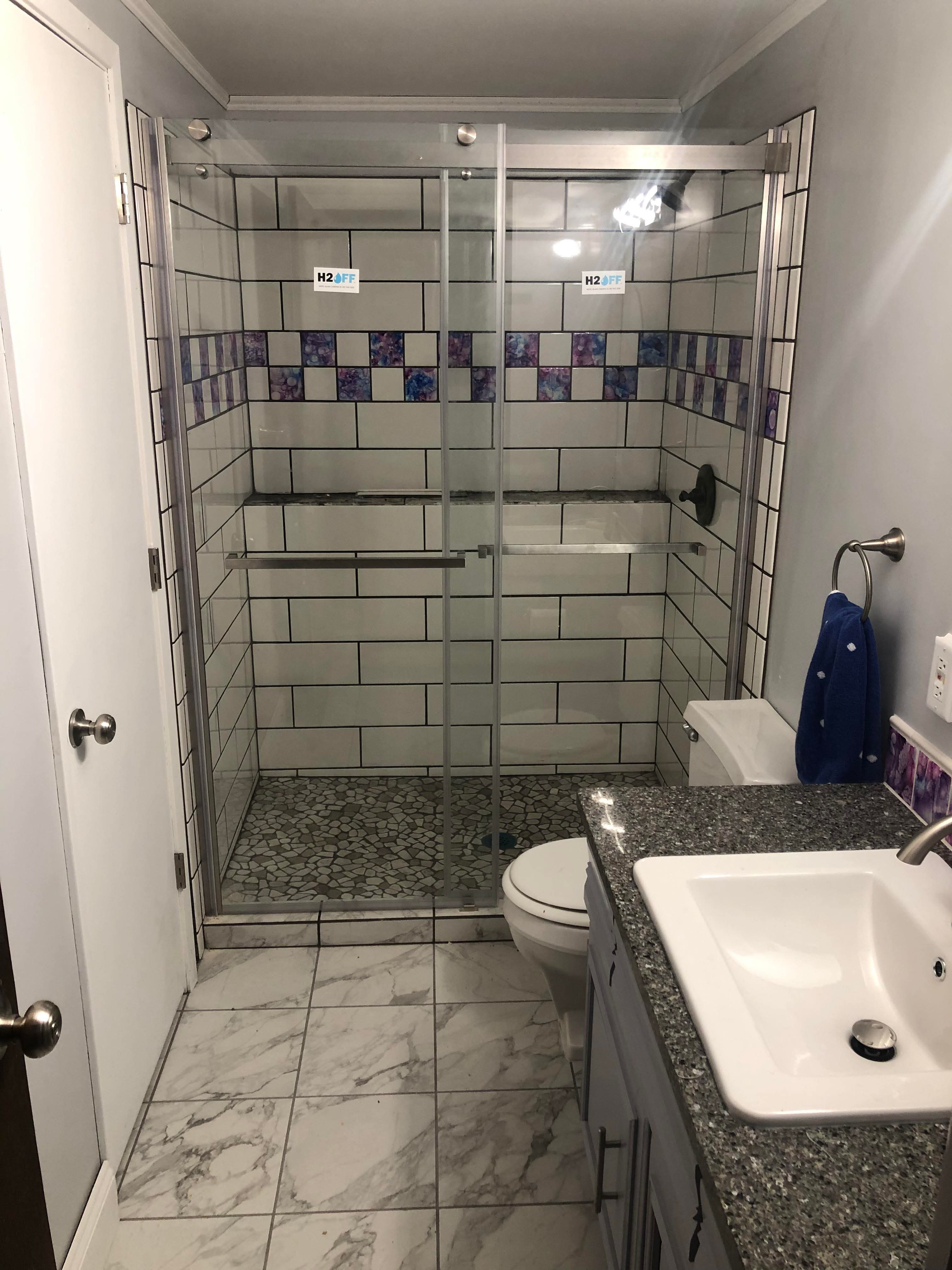 Finished bathroom tile installation with decorative accent detail