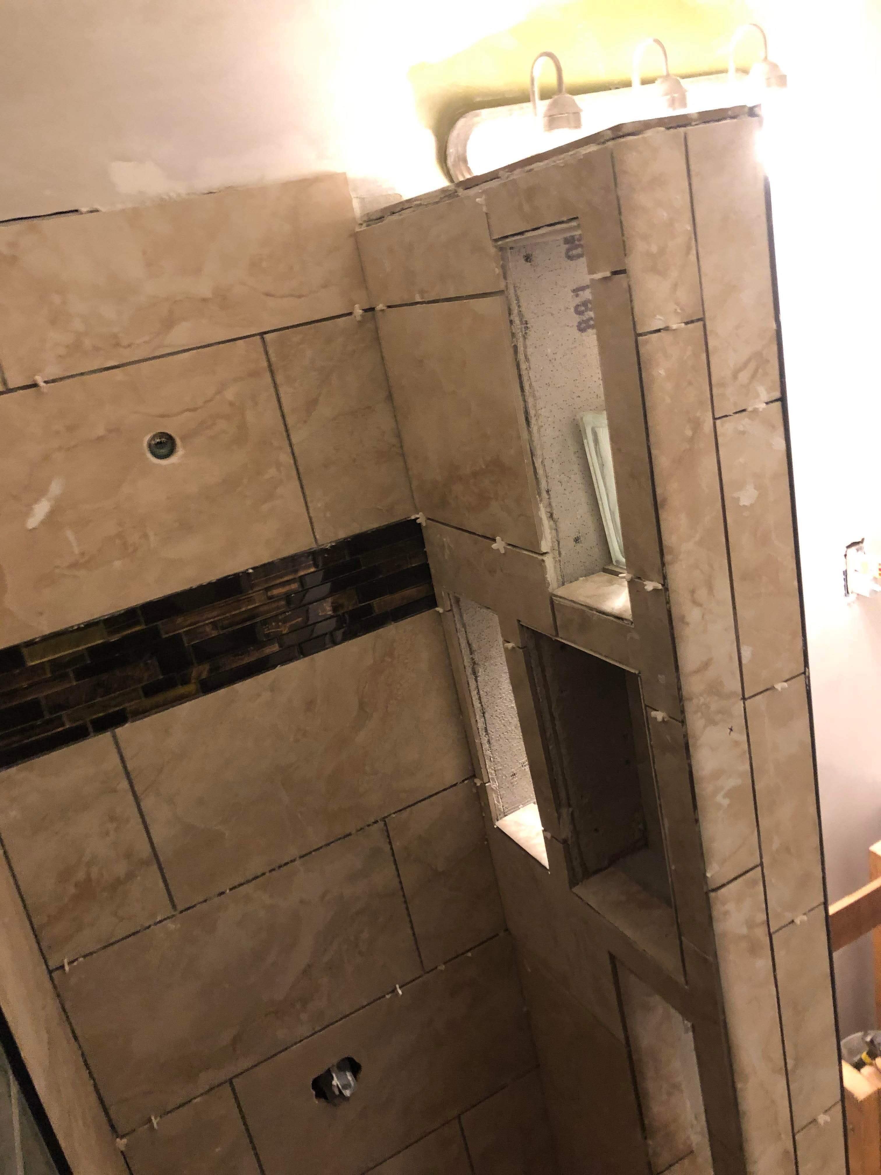 Large-format tile shower installation with built-in niche shelving
